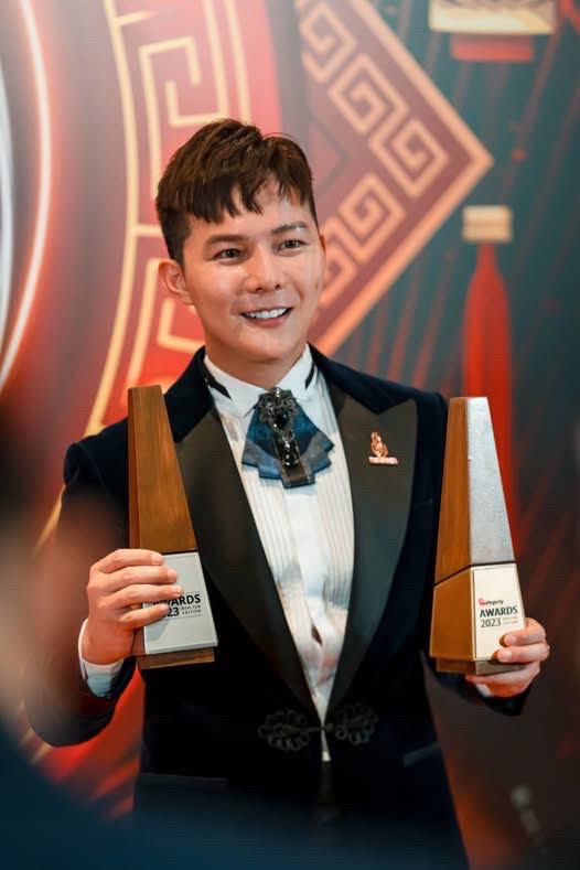 Zax holding two StarProperty award trophies